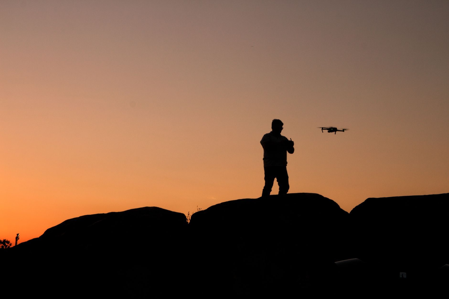 Drone silhouetted against a wide evening sky
